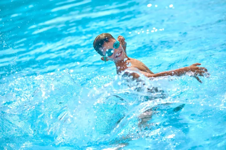 Boy swimming in pool with salt water system on Long Island - Salt Water Pool vs Chlorine Pool